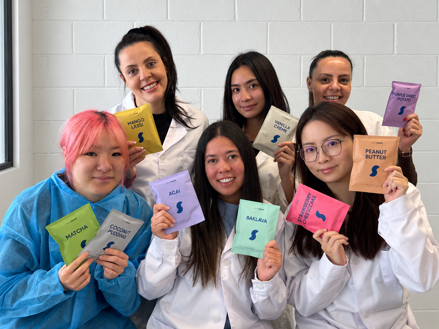 Daily Shake's female-led Sydney laboratory and manufacturing team holding Daily Shake sachets